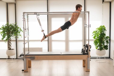 Bir adam yenilikçi bir makine üzerinde hava tatbikatları yapıyor.