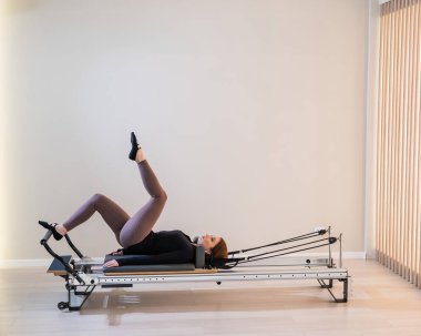 Reform üzerine pilates yapan kadın