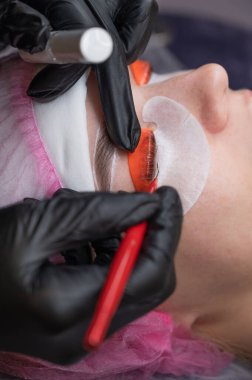 Beyaz kadın kirpik temizleme prosedüründen geçiyor.