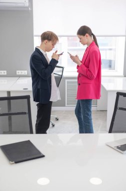 Meslektaşlar iş yerinde akıllı telefon kullanırlar.