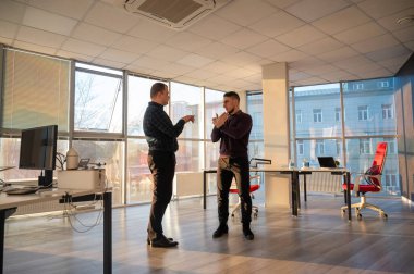 Ofiste konuşan iki beyaz adam.