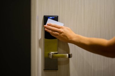 Bir kadın kartla elektronik kilidi açar ve bir otel odasına girer.