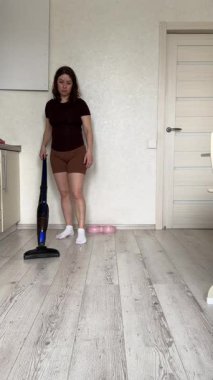 Beyaz kadın yerleri süpürüyor.