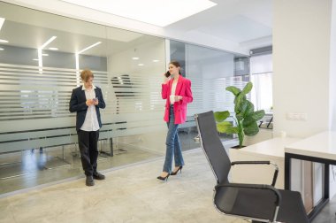 Meslektaşlar iş aralarında akıllı telefon kullanırlar