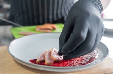 Şef ördeği kızılcık sosuna koyar.