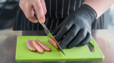Şef ördeği dilimliyor.