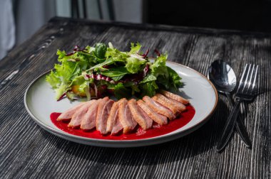 Kızarmış ördek bir tabakta parçalara ayrılmış.