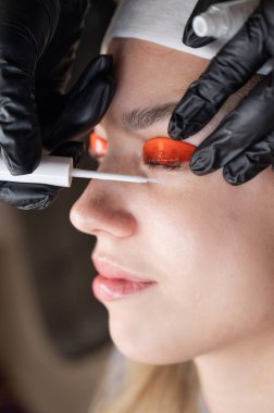 Beyaz kadın kirpik temizleme prosedüründen geçiyor.