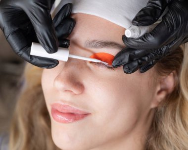 Beyaz kadın kirpik temizleme prosedüründen geçiyor.