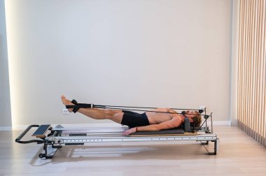 Reformcu üzerinde pilates yapan bir adam.