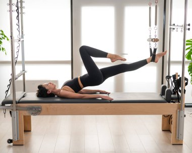 Asyalı kadın reformcuda pilates yapıyor.