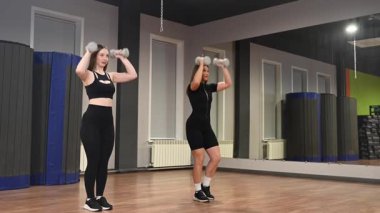 İki beyaz kadın dambıllarıyla saldırıyor.