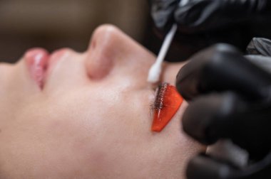 Beyaz kadın kirpik temizleme prosedüründen geçiyor.