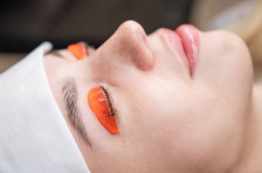 Beyaz kadın kirpik temizleme prosedüründen geçiyor.