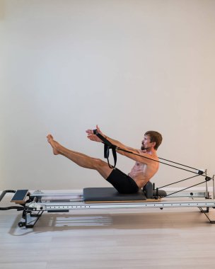 Reformcu üzerinde pilates yapan bir adam.