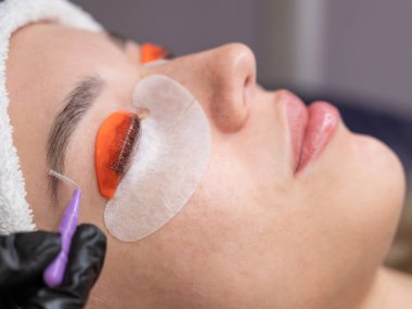 Beyaz kadın kirpik temizleme prosedüründen geçiyor.