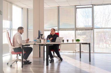 Bir ofiste çalışan iki beyaz adam.