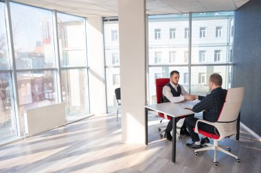 İki beyaz adam el sıkışıyor. Röportaj veya iş toplantısı