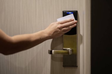Bir kadın kartla elektronik kilidi açar ve bir otel odasına girer.