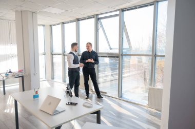 Ofiste konuşan iki beyaz adam.