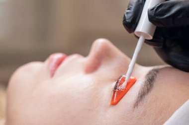 Beyaz kadın kirpik temizleme prosedüründen geçiyor.