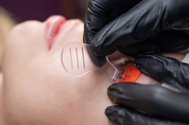 Beyaz kadın kirpik temizleme prosedüründen geçiyor.