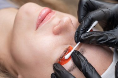 Beyaz kadın kirpik temizleme prosedüründen geçiyor.