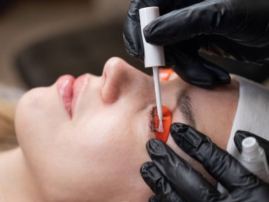 Beyaz kadın kirpik temizleme prosedüründen geçiyor.