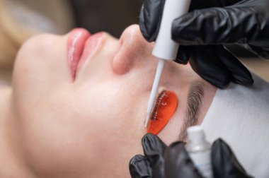 Beyaz kadın kirpik temizleme prosedüründen geçiyor.