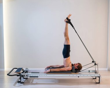 Reformcu üzerinde pilates yapan bir adam.