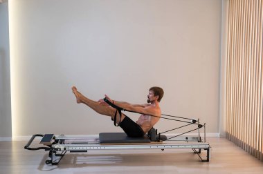 Reformcu üzerinde pilates yapan bir adam.