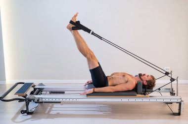 Reformcu üzerinde pilates yapan bir adam.