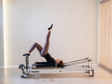 Reform üzerine pilates yapan kadın