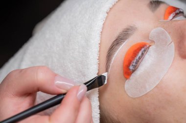 Beyaz kadın kirpik temizleme prosedüründen geçiyor.