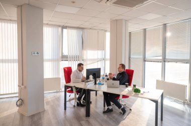 Bir ofiste çalışan iki beyaz adam.