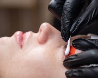 Beyaz kadın kirpik temizleme prosedüründen geçiyor.