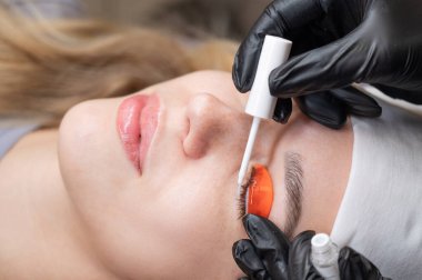 Beyaz kadın kirpik temizleme prosedüründen geçiyor.