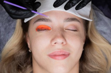 Beyaz kadın kirpik temizleme prosedüründen geçiyor.