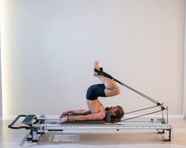 Reformcu üzerinde pilates yapan bir adam.