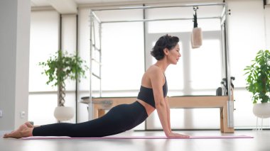 Asyalı kadın yukarı doğru köpek egzersizi yapıyor. Yoga sınıfı.