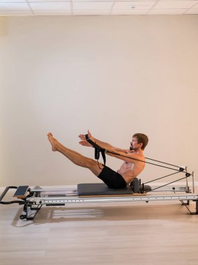 Reformcu üzerinde pilates yapan bir adam.