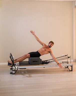 Reformcu üzerinde pilates yapan bir adam.