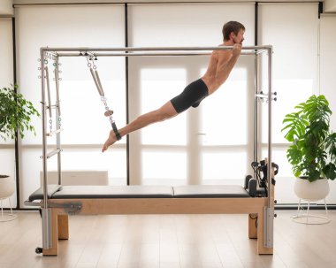 Bir adam yenilikçi bir makine üzerinde hava tatbikatları yapıyor.