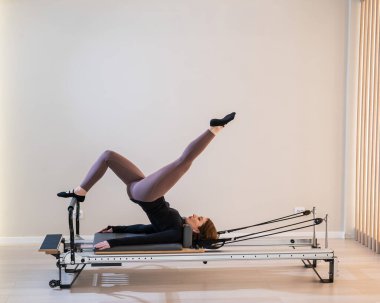 Reform üzerine pilates yapan kadın