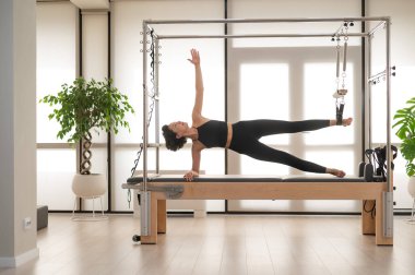 Asyalı kadın reformcuda pilates yapıyor.