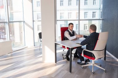 İki beyaz adam el sıkışıyor. Röportaj veya iş toplantısı