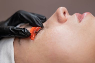 Beyaz kadın kirpik temizleme prosedüründen geçiyor.