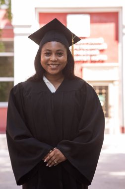 Mezuniyet elbisesi içinde mutlu bir Afrikalı kadın.
