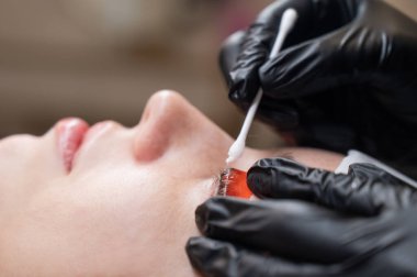 Beyaz kadın kirpik temizleme prosedüründen geçiyor.