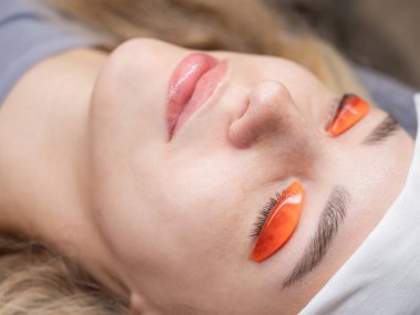 Beyaz kadın kirpik temizleme prosedüründen geçiyor.